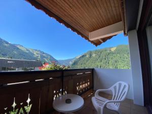 d'un balcon avec une table, des chaises et des montagnes. dans l'établissement Hôtel Macchi Restaurant & Spa, à Châtel