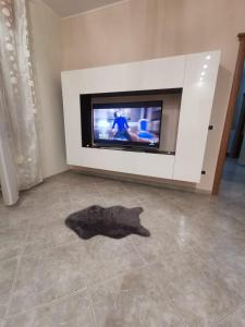 un animal negro tirado en el suelo frente a una TV en Superbe Appartement de 5 pièces avec 3 grandes chambres situé dans un jolie village, en Montefalcione