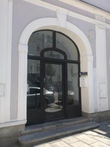 順佩爾克的住宿－Apartmány na náměstí，通往大楼的拱形门道,有黑色的门