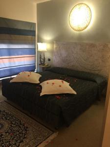 a bedroom with a black bed with two pillows at Hotel Feel Inn Venice Airport Rooms in Campalto