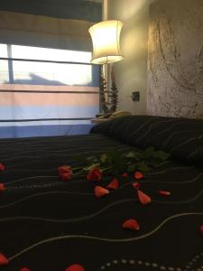 Un dormitorio con una cama con rosas rojas. en Hotel Feel Inn Venice Airport Rooms, en Campalto