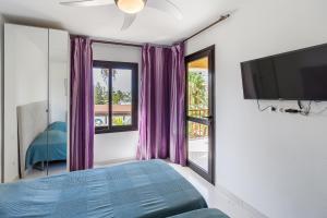 een slaapkamer met een bed en een flatscreen-tv bij Amazing 3 bedroom apartment on the first line of the best Las Americas beach, air conditioner and terrace ocean view in Playa de las Americas