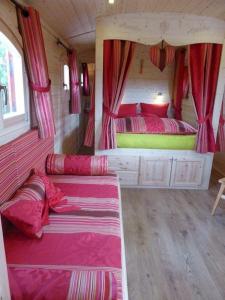 um quarto com 2 camas num pequeno quarto em La Roulotte de Bourgogne em Brianny