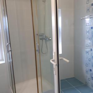 a shower stall with a glass door with a shower at Green House in Eforie Sud
