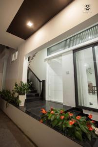 Casa con balcón con flores en el suelo en Moonlight House & Apartment Nha Trang, en Nha Trang