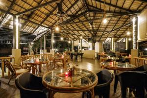 a restaurant with tables and chairs in a room at Kuruva Island Resort And Spa - By KABINI BREEZE, Wayanad in Mananthavady