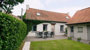 a patio with a table and chairs in a house at Vakantiehuis DE RIEKE 16 personen in Ronse