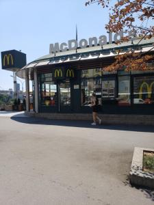 a woman standing in front of a mcdonalds restaurant at Cozy room in appartment, with shared bathroom,downtown Belgrade in Belgrade