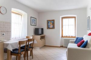 ein Wohnzimmer mit einem Tisch und einem Sofa in der Unterkunft Cà dei Giani in Montagnaga