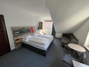 Hotel Am Tiergarten في نوربرغ: غرفة نوم بسرير وطاولة وكرسي