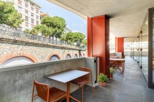 un restaurante con mesa y sillas en el balcón en B&B Hotel Genova City Center, en Génova