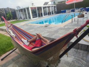 un hombre tendido en una hamaca junto a una piscina en BIG DREAMS Al en Vila do Conde
