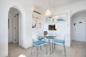 a dining room with a glass table and blue chairs at BLUE LAGOON in Port d'Alcudia