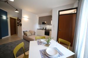 een keuken en een woonkamer met een witte tafel en stoelen bij Casa Ercoli Abbadia in Abbadia di Montepulciano