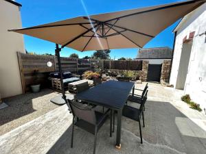 a table and chairs with an umbrella on a patio at Villa Quiberon, 5 pièces, 8 personnes - FR-1-478-205 in Quiberon