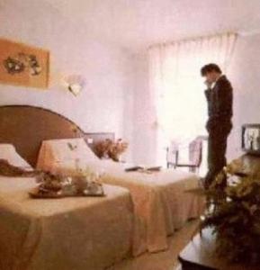a man standing by a window in a room with two tables at Hotel Ambasciatori in Calitri
