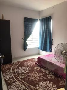 a bedroom with a bed and a window with a fan at Homestay Ar Rayyan RESIDENSI LAGUNA BIRU in Rawang
