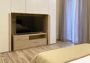 een slaapkamer met een flatscreen-tv en een bed bij Sami B&B and holidays home in Taranto