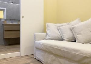 un letto con cuscini bianchi in una stanza di Sami B&B and holidays home a Taranto