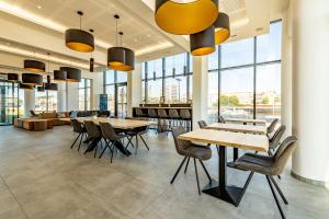 a cafeteria with tables and chairs and windows at Evancy La Marina Boulogne-sur-Mer in Boulogne-sur-Mer