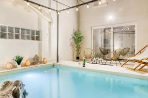 uma piscina interior com cadeiras e uma piscina em Swim&Chill By Weloveyou em Cormeilles-en-Parisis