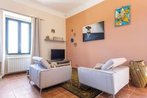 a living room with two chairs and a tv at La Torre di Barbara in Ardea