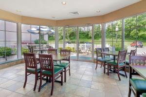 a dining room with a table and chairs and windows at Best Western Lexington Inn in Lexington