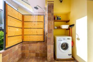 eine Waschmaschine und einen Trockner im Bad mit einer Wand in der Unterkunft Casa Titina in Capoterra