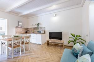 ein Wohnzimmer mit einem Esstisch und einer Küche in der Unterkunft Casa Titina in Capoterra