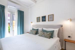 ein Schlafzimmer mit einem weißen Bett mit Kissen und einem Fenster in der Unterkunft Casa Titina in Capoterra