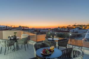 a balcony with tables and chairs with a view of a city at Casa Del Balsamo in Rethymno Town