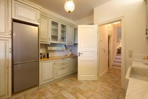 eine Küche mit weißen Schränken und einem Kühlschrank in der Unterkunft Sun-rock house by the sea in Ándros