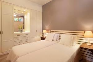 um quarto branco com 2 camas e uma janela em Sun-rock house by the sea em Andros