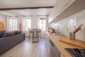 uma cozinha e sala de estar com um sofá e uma mesa em LES ARCHES - BELLE DECORATION - WIFI - AC CLiM em Villeneuve-lès-Avignon