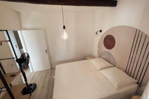 um quarto com uma cama branca e uma câmara em LES ARCHES - BELLE DECORATION - WIFI - AC CLiM em Villeneuve-lès-Avignon