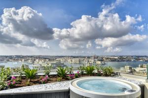 a hot tub on a balcony with a view of the city at Palazzo Ignazio in Valletta