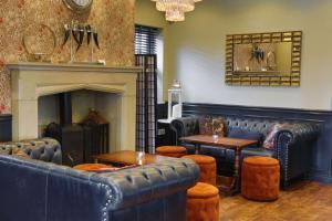 um restaurante com mobiliário de couro azul e uma lareira em The Eccleston Hotel; BW Signature Collection em Saint Helens