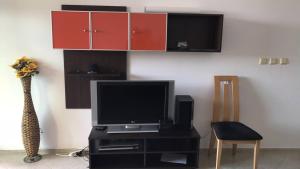 uma sala de estar com televisão e armários vermelhos em Black Sea Paradise Hotel em Sozopol
