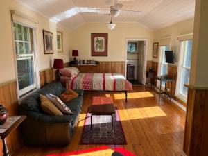 uma sala de estar com um sofá e uma cama em The Dairy Cottage - Lake Lorne - Drysdale em Drysdale