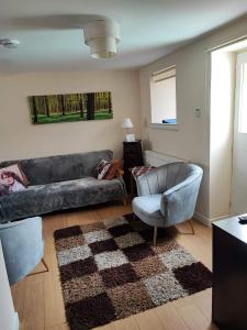 a living room with a couch and a chair at The Hayloft in Falkland