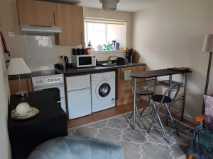 a small kitchen with a stove and a washer and dryer at The Hayloft in Falkland