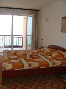 a large bed in a room with a large window at Villa Cvet Rooms in Ohrid