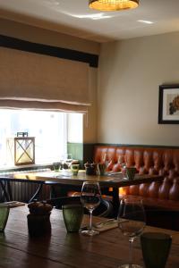 a dining room with a table and a leather couch at The Kings Head in Whiteparish
