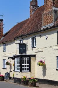 a white building with flowers in front of it at The Kings Head in Whiteparish