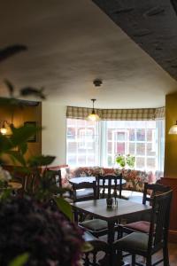 a dining room with a table and chairs and a couch at The Kings Head in Whiteparish