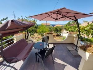 un patio con mesa y sombrilla en Apartman Lovre en Zadar