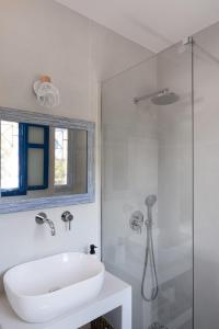 a white bathroom with a sink and a shower at Absolute Perdika Aegina in Perdika