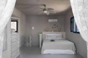 a bedroom with a bed and a ceiling fan at Absolute Perdika Aegina in Perdika