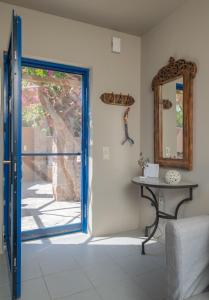 an open door in a room with a table and a mirror at Absolute Perdika Aegina in Perdika