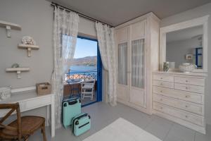 a bedroom with a desk and a view of the ocean at Absolute Perdika Aegina in Perdika